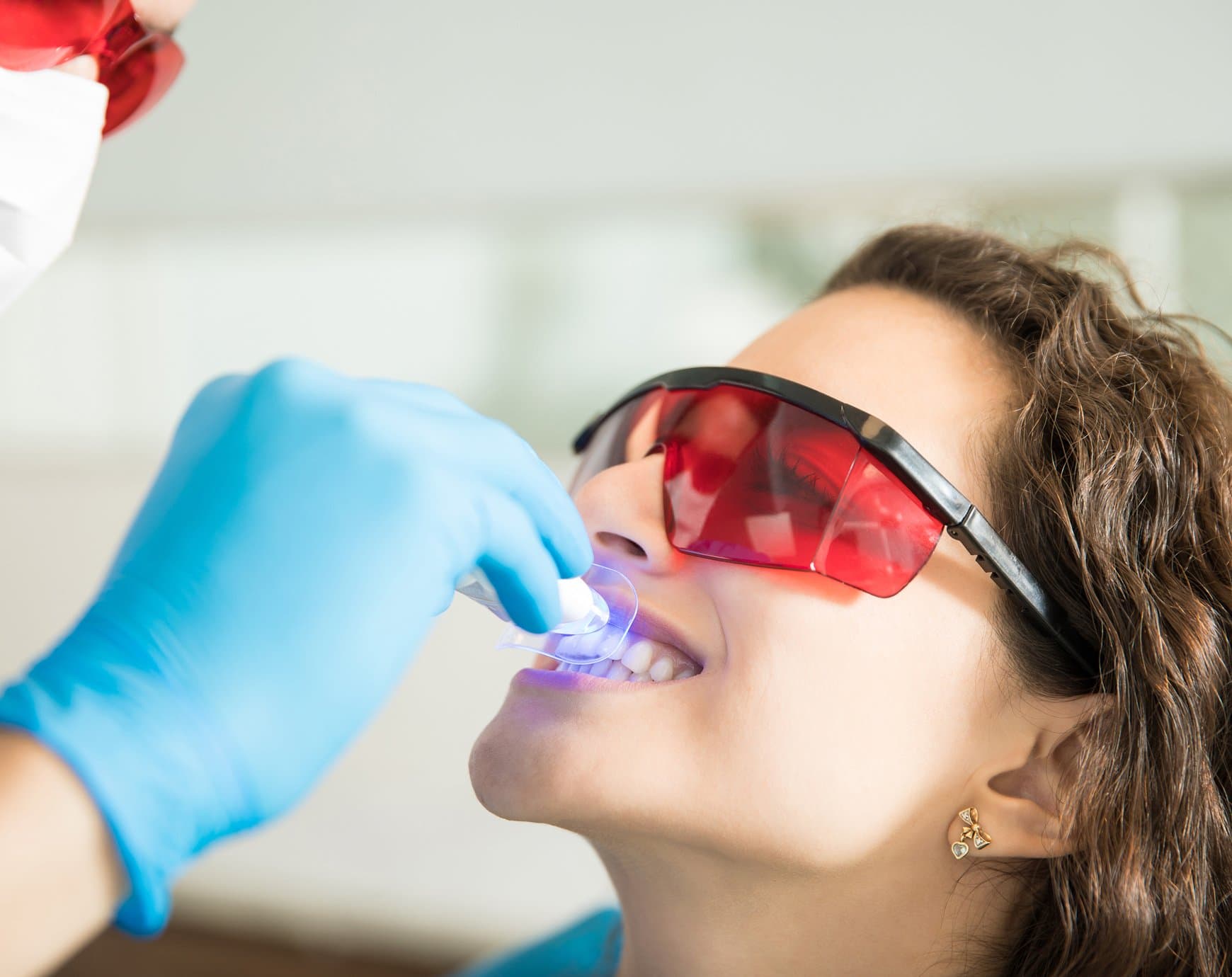 Woman wearing protective glasses during a teeth whitening treatment