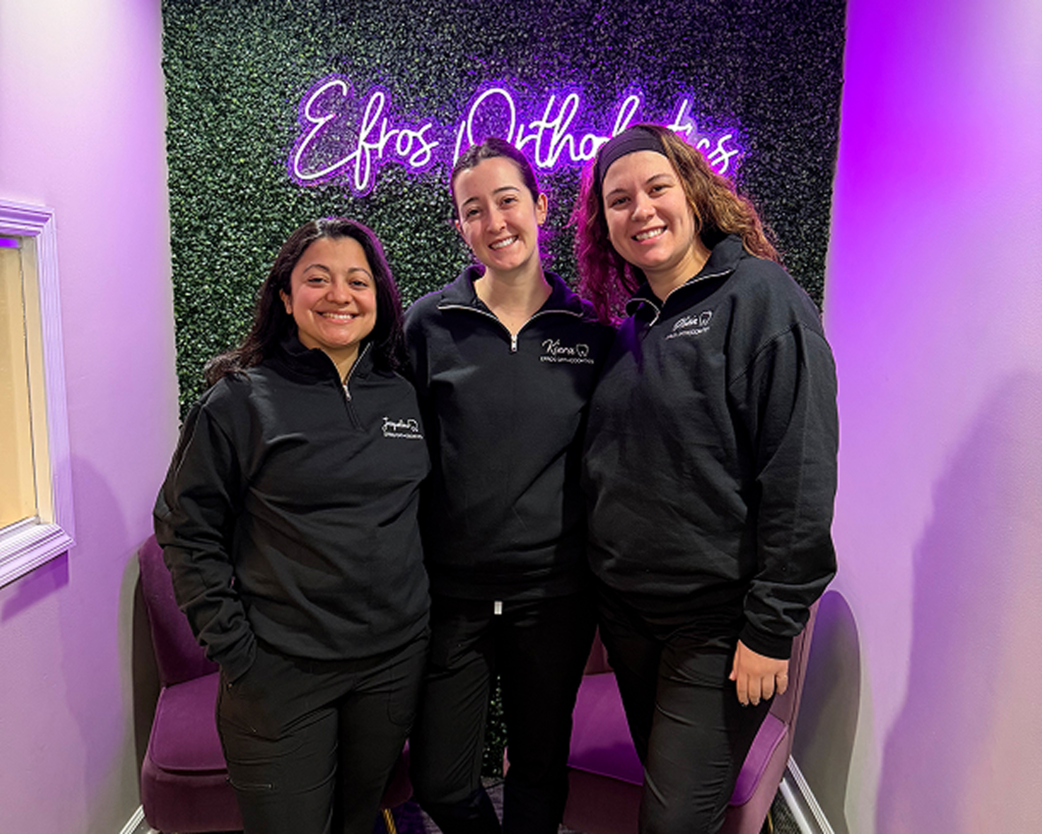 Efros Orthodontics team in front of the neon sign